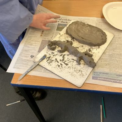 Children making clay lizards